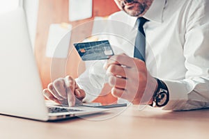 E-business, businessman using credit card and laptop computer for online financial transaction