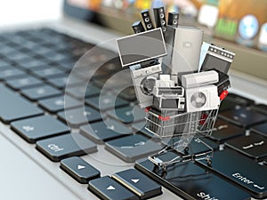 E-commerce or online shopping concept. Home appliance in shopping cart on the laptop keyboard. photo