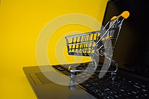 E-Commerce. Online shopping, shopping cart on laptop keyboard.