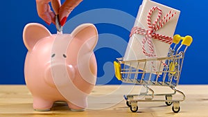 Retail savings shopping concept with miniature shopping cart and piggy bank.
