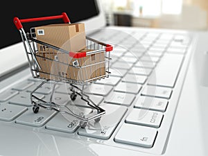 E-commerce. Shopping cart with cardboard boxes on laptop.