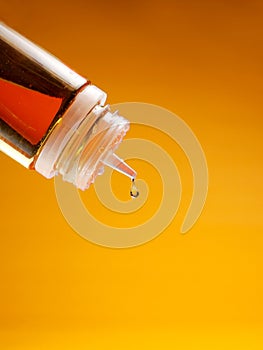e-juice dripping. e-liquid, vape liquid dripping on orange yellow background, good for advertising. Mockup , on an orange backgrou