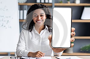 E-Learning Concept. Smiling Black Female Tutor Showing Big Blank Smartphone At Camera