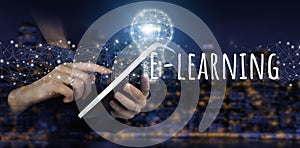 E-learning Internet Education Webinar Online Courses.Hand touch white tablet with digital hologram light bulb, e-learning sign on