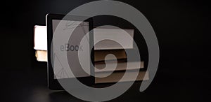 E reader. Digital e book, library reader tablet with books on dark background. Online education course, E learning class