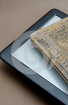 E reader emerging from an very old book, with beautiful covers