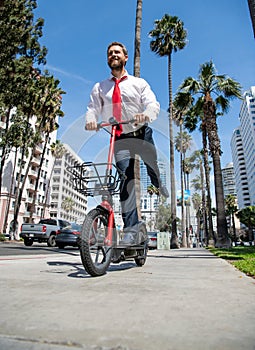 E-scooting along. Happy man ride e-scooter on street. E-scooting. Electric transportation