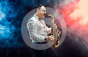 Handsome adult man playing saxophone