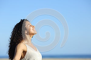 Relaxed young woman breating and enjoying sun on the beach photo