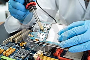 E-waste, technician repairing inside of hard disk by soldering iron. Integrated Circuit. the concept of data, hardware, technician