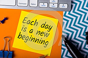 Each day is a new beggining - motivational note on office background