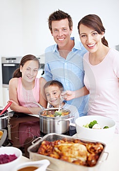 Each doing their part to make an awesome meal. Portrait of a delighted family cooking a large, delicous meal in the