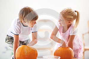 They each get theyre own pumpkin every year. A little boy and girl hollowing out their jack-o-lantern.