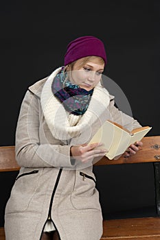 Eading young woman in winter clothes on black