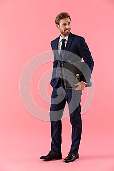 Eager businessman holding a briefcase and curiously looking away