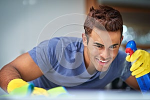 Eager to clean. Shot of a young man doing household chores.