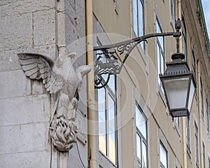 Eagle and a black street lamp whose holder incorporates two ravens on a boat, the symbol of Lisbon.