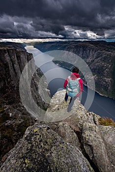 Eagle head viewpoint near Kjeragbolten Lysebotn Norway Woman stands by the edge of lysefjord