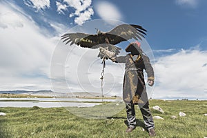 Eagle Hunter holding Golden Eagle while Spreading its large wings