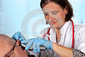 Ear examination by a doctor with otoscope.