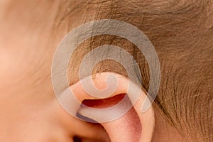 Ear and hair of the newborn baby, macro, close up, maternal care, love and family hugs, tenderness