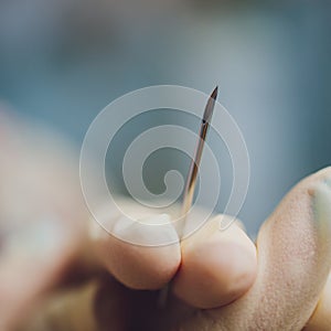 ear jewelry, piercing in hand with a disposable glove.