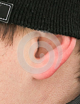 The ear of a man in a hat as a background