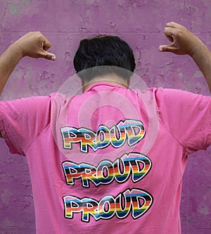 ear view of gay asian man wearing a pink shirt that says Proud, embracing and supporting LGBTQ community