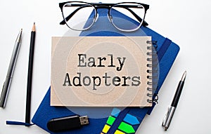 EARLY ADOPTERS text on a notebook on green paper photo