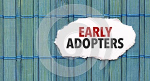 early adopters word on torn paper with blue wooden background photo