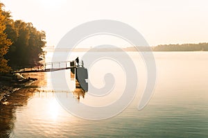 Lone fisherman on the riverbank in the early autumn morning