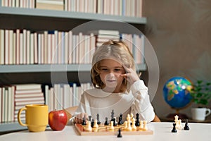 Early development. Child thinking about chess. The concept of learning and growing children. Chess, success and winning.