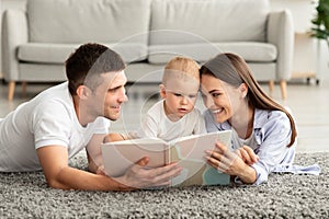 Early Education For Kids. Parents Reading Book To Their Cute Toddler Son