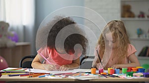 Early education, two multi-ethnic female kids drawing with colorful pencils