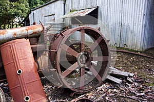 Early farm machinery discarded behind a shed