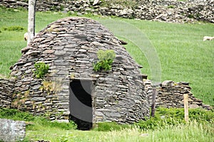 Early medieval stone-built round house clochain beehive hut on Dingle Peninsula, Kerry, Ireland. A Clochain is a dry-stone hut photo