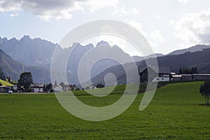 Early morning in Austria. Traditional Austrian landscape: mountains, cozy houses and green lawns.