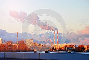 Early morning with down sun light, a view to the industrial landscape of the city with smoke emissions from chimneys