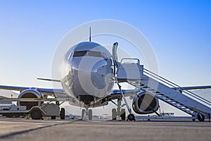 Early morning flight. Front view of an airplane boarding at a terminal gate