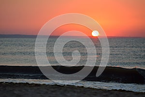 Early morning, the image of the sea at the sunrise. Waves, red s