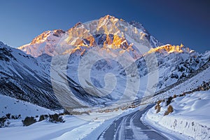 Early morning light casting shadows on snow-capped mountains, clear blue sky.. AI generated.