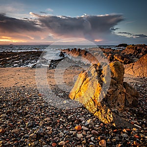 The early morning light on a large rock on the beach at St Monans on the east coast of Scotland