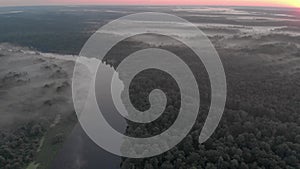 Early morning misty landscape with a winding river at sunrise. Aerial view