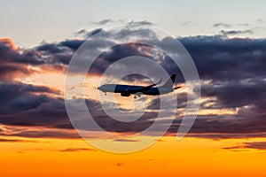 Early morning passenger aircraft flying against the backdrop of a scenic sky. Airplane silhouette