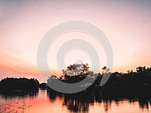 Early Morning on the river lake silhouette forest refection on water beautiful color of sunset sunrise nature background