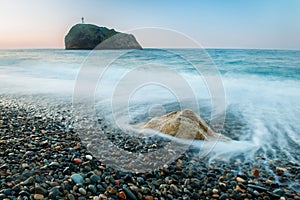 Early morning on a scenic pebbly beach.