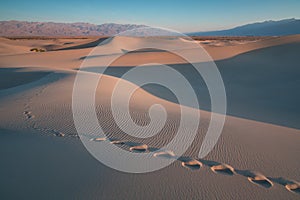 Early Morning Sunlight Over Sand Dunes And Mountains At Mesquite flat dunes, Death Valley National Park, California USA