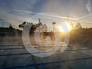 Early morning sunrise above steamy pool