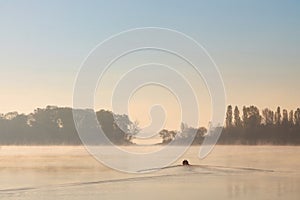 Early morning sunrise, boating on the lake in a huge fog