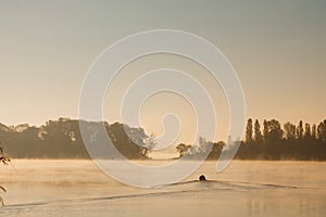 Early morning sunrise, boating on the lake in a huge fog